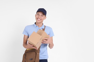 Photo of Happy postman with bag and parcels on white background