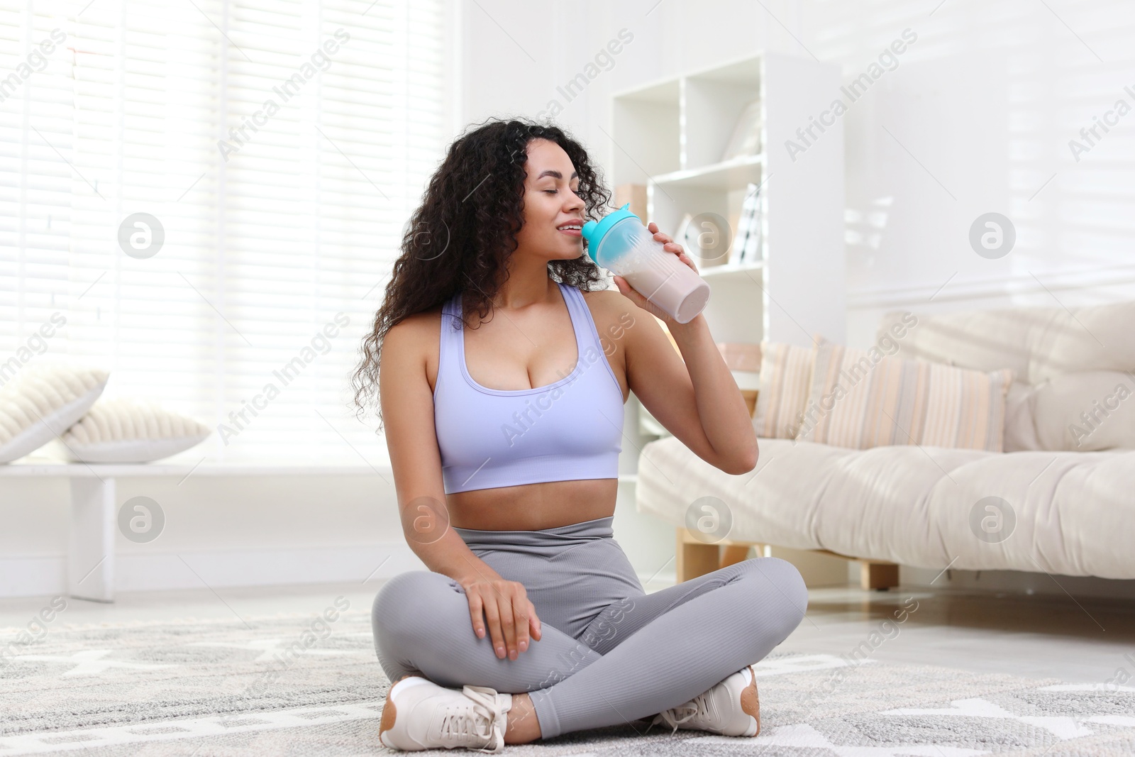 Photo of Beautiful woman drinking protein shake at home