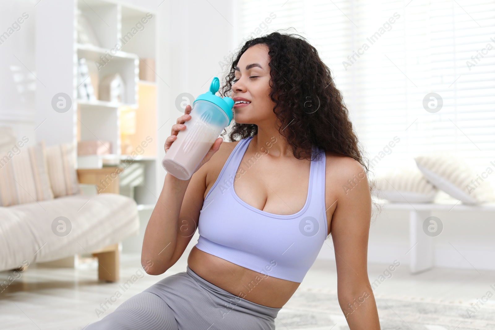 Photo of Beautiful woman drinking protein shake at home