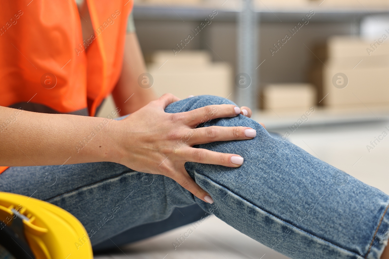 Photo of Accident at work. Woman with injured leg on floor indoors, closeup