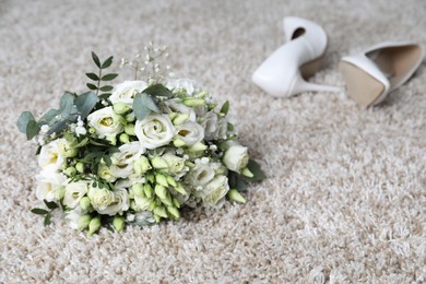 Photo of Wedding bouquet of beautiful flowers and bridal shoes on beige carpet, selective focus