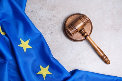 Photo of Judge's gavel and flag of European Union on grey table, top view