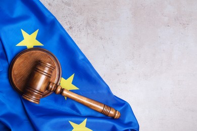 Photo of Judge's gavel and flag of European Union on grey table, top view. Space for text