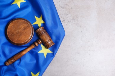 Photo of Judge's gavel and flag of European Union on grey table, top view. Space for text