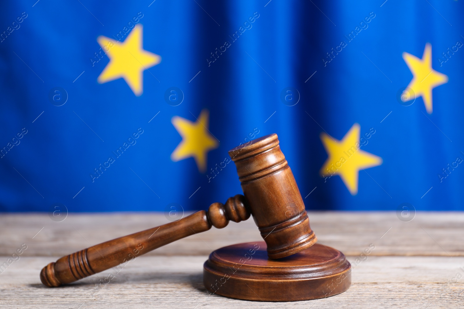 Photo of Judge's gavel on wooden table against European Union flag