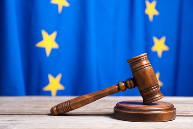 Photo of Judge's gavel on wooden table against European Union flag