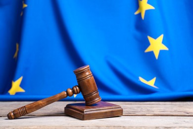 Photo of Judge's gavel on wooden table against European Union flag, space for text