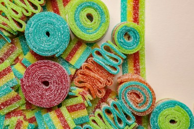 Photo of Different tasty sour belts on beige background, top view