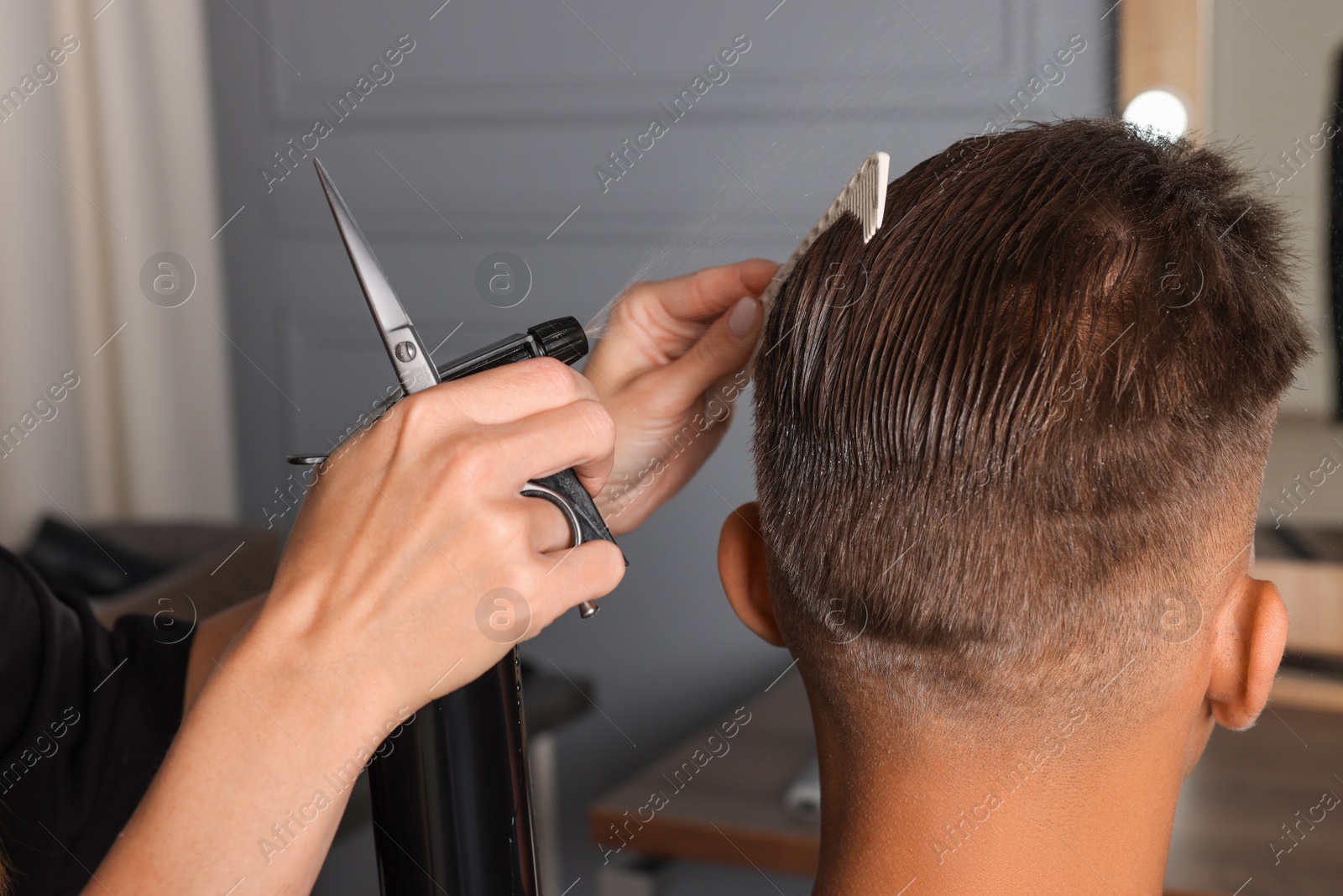 Photo of Hair cutting. Professional hairdresser working with client in barbershop, closeup