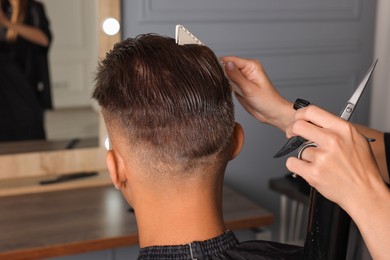 Photo of Hair cutting. Professional hairdresser working with client in barbershop, closeup