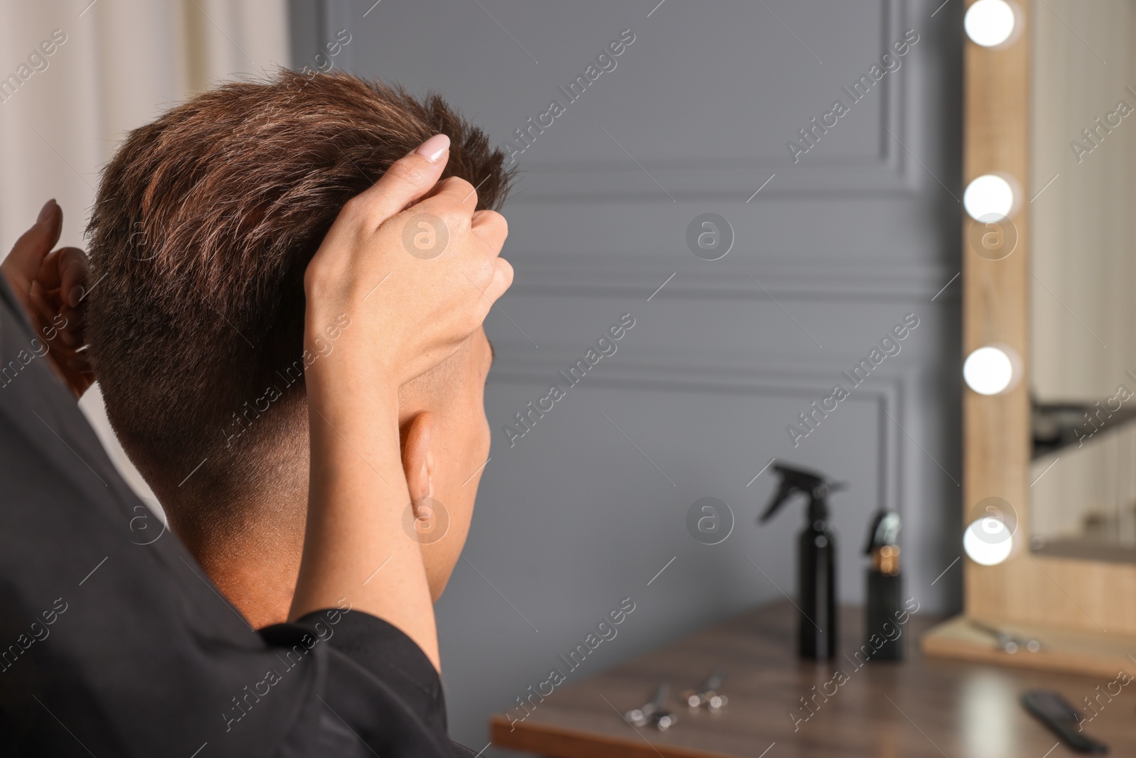 Photo of Hair cutting. Professional hairdresser working with client in barbershop, closeup. Space for text