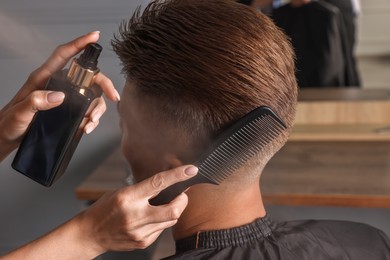 Photo of Hair cutting. Professional hairdresser working with client in barbershop, closeup