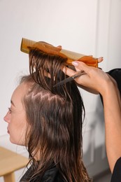 Photo of Hair cutting. Professional hairdresser working with client in salon, closeup