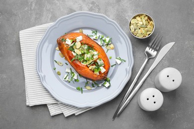 Photo of Tasty cooked sweet potato with feta cheese, pumpkin seeds and green onion on grey table, top view