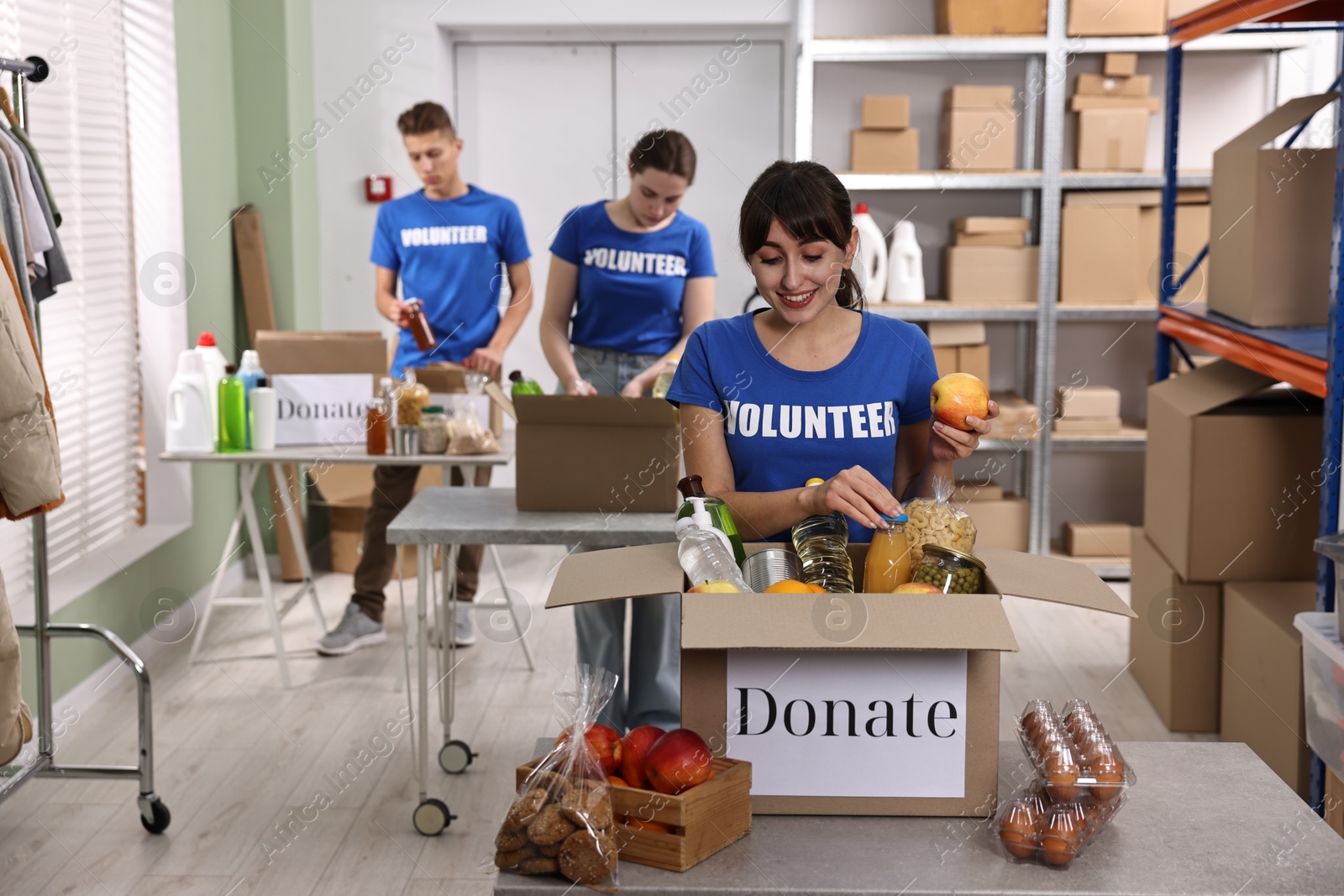 Photo of Volunteers packing food donations at tables indoors