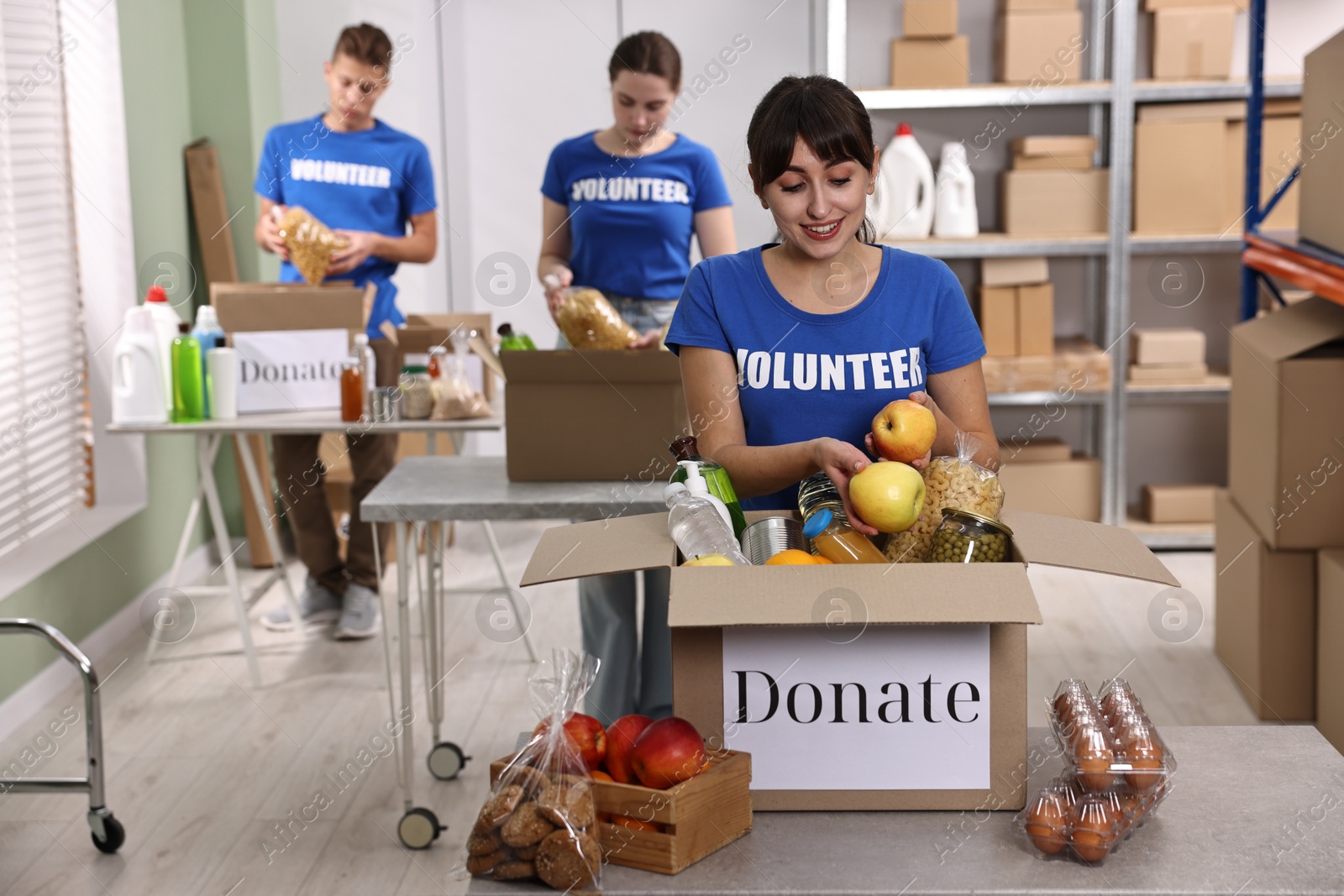 Photo of Volunteers packing food donations at tables indoors