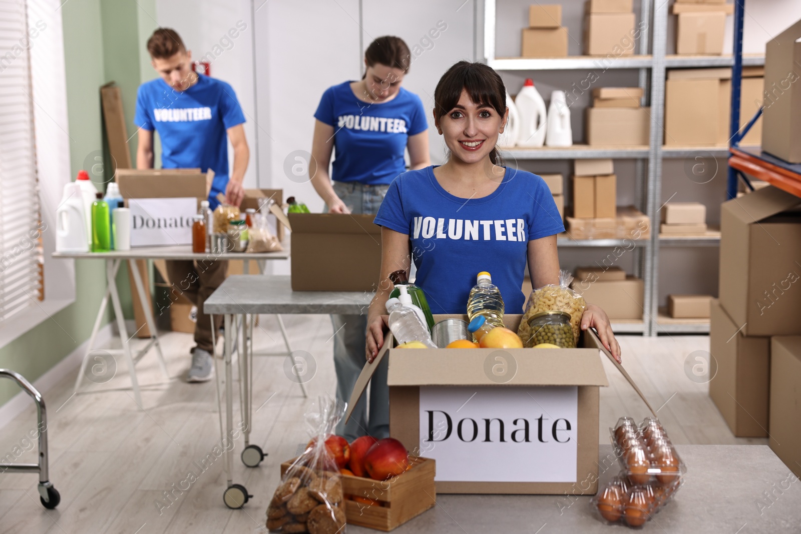 Photo of Volunteers packing food donations at tables indoors