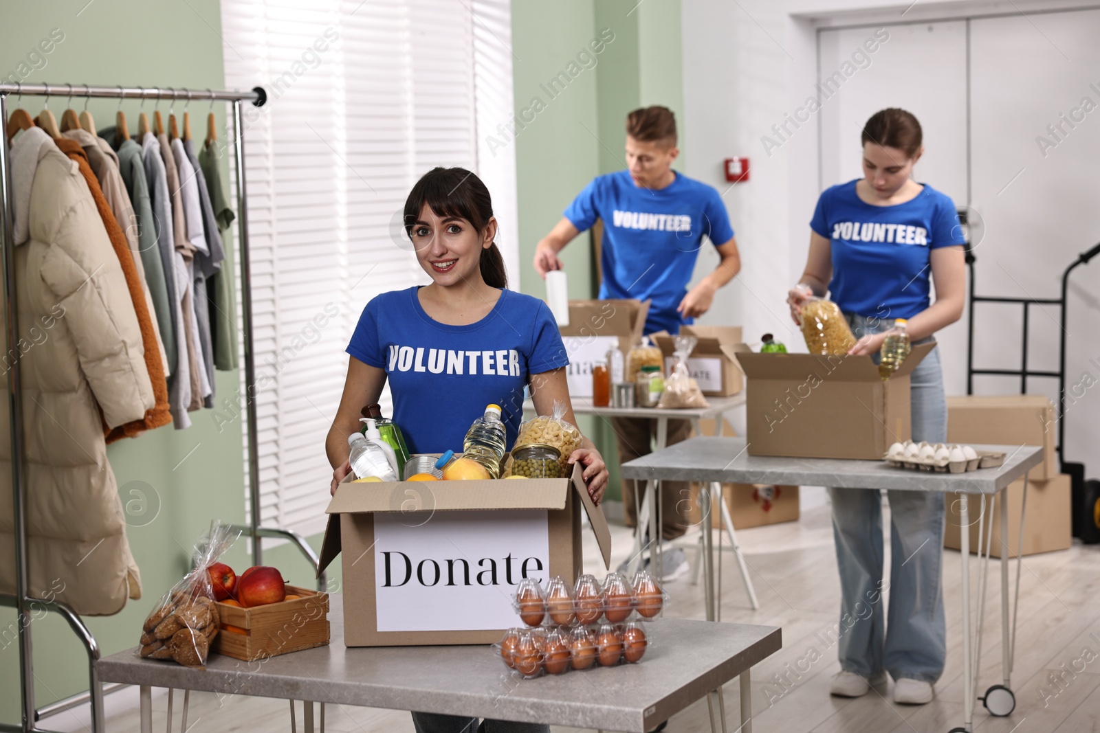 Photo of Volunteers packing food donations at tables indoors