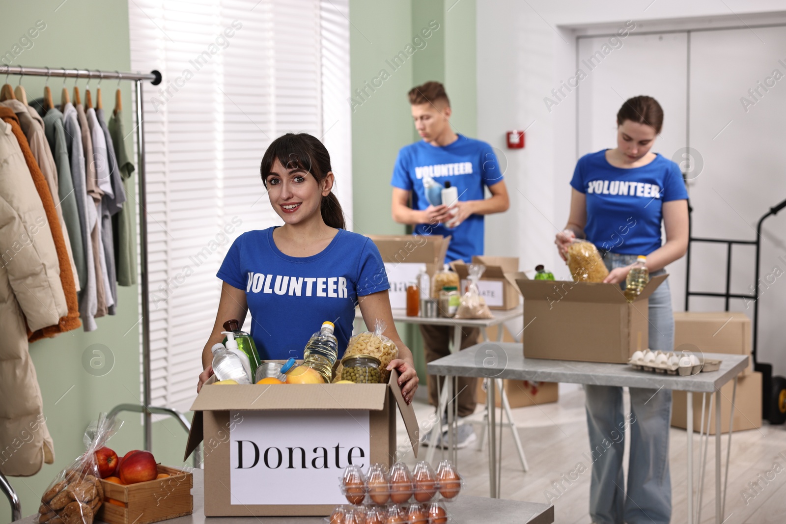 Photo of Volunteers packing food donations at tables indoors