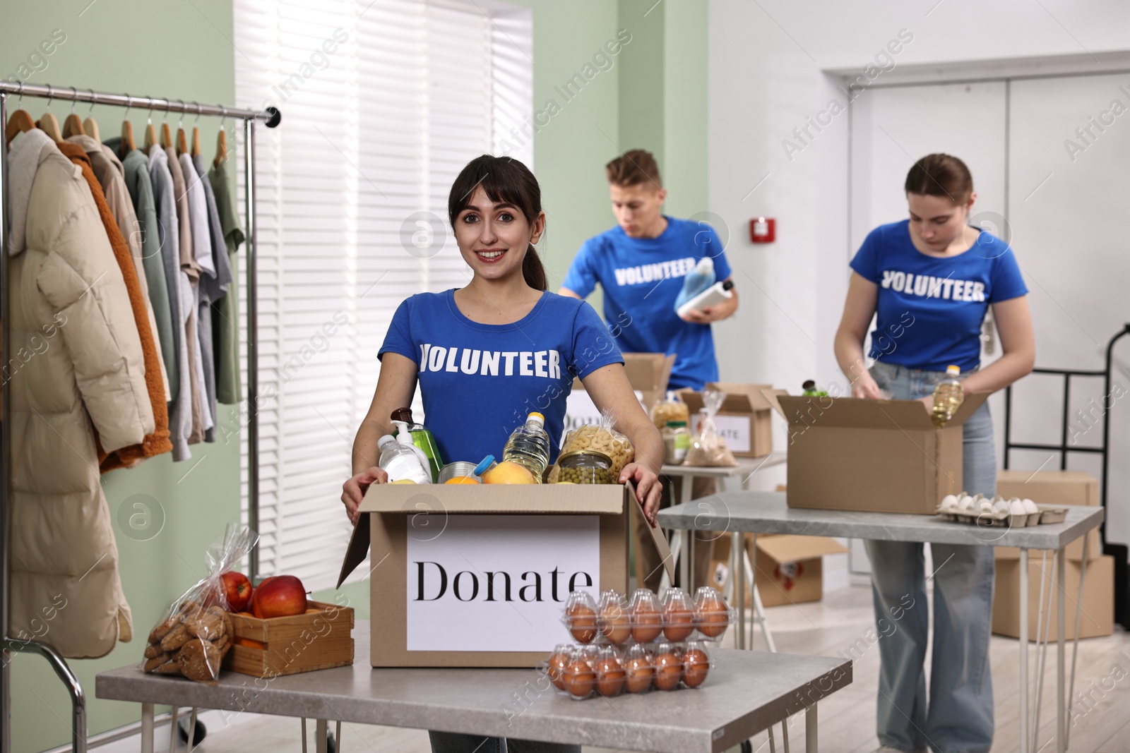 Photo of Volunteers packing food donations at tables indoors