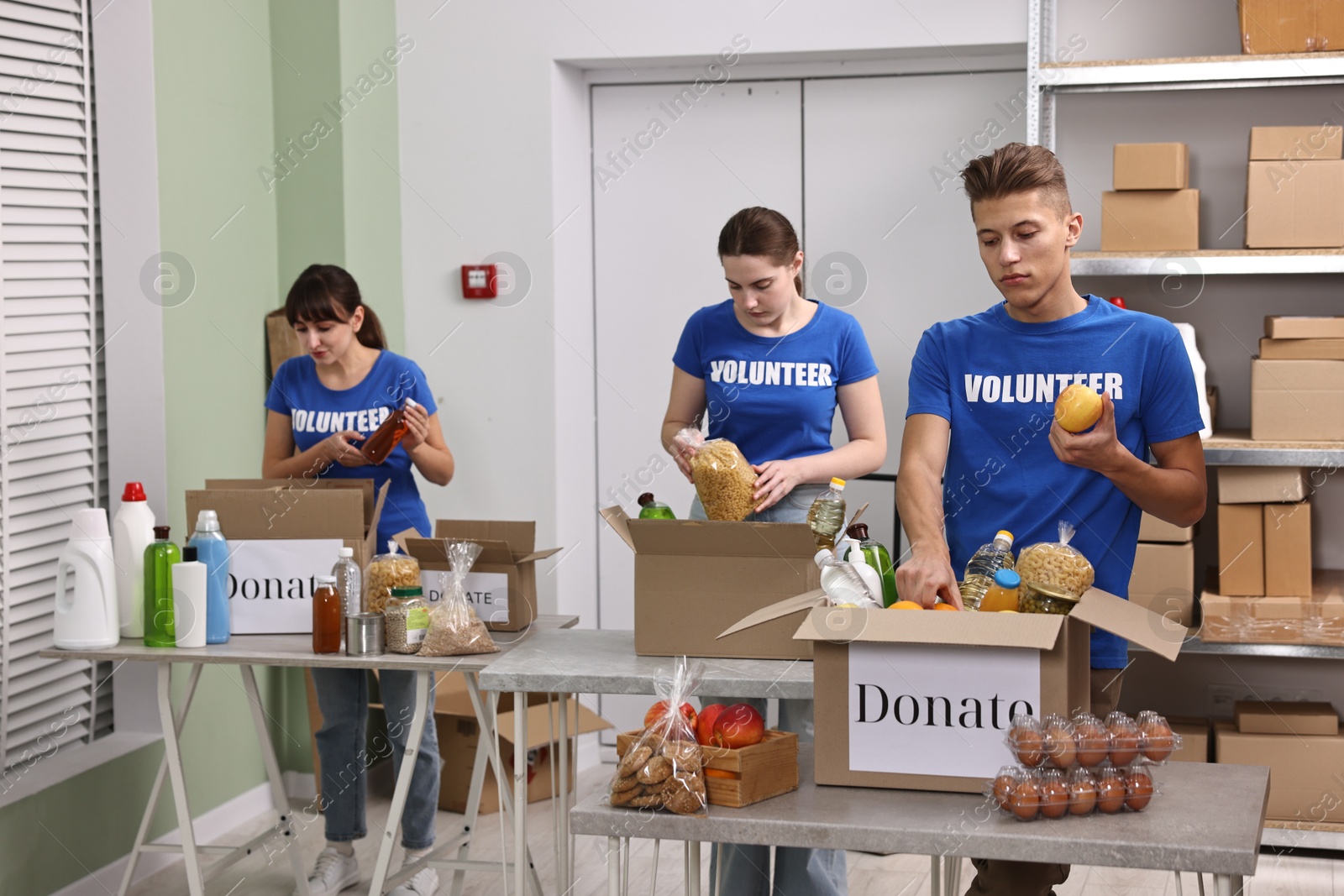 Photo of Volunteers packing food donations at tables indoors