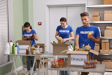 Photo of Volunteers packing food donations at tables indoors