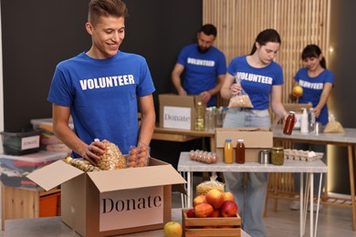 Photo of Volunteers packing food donations at tables indoors