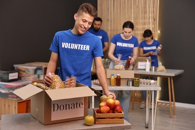 Photo of Volunteers packing food donations at tables indoors