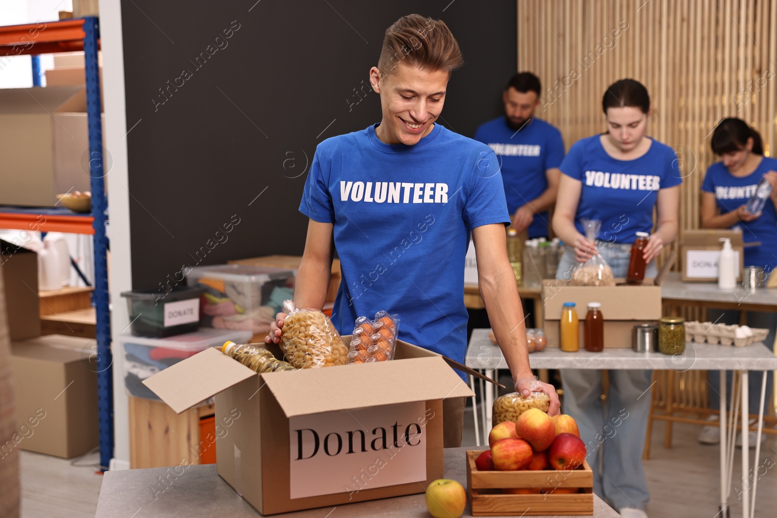 Photo of Volunteers packing food donations at tables indoors