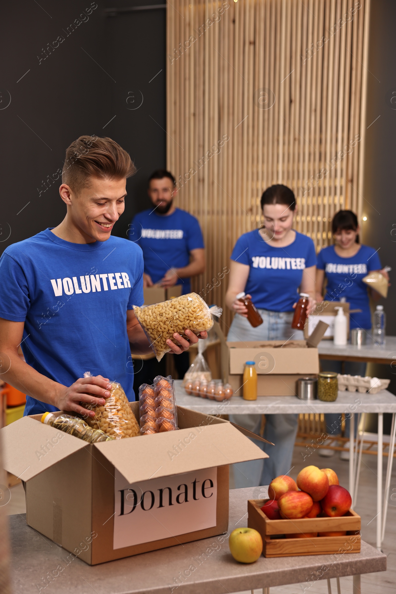 Photo of Volunteers packing food donations at tables indoors