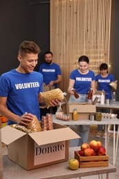 Photo of Volunteers packing food donations at tables indoors