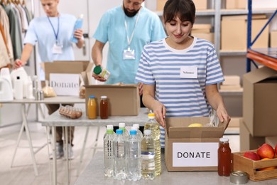 Photo of Volunteers packing donation goods at tables indoors