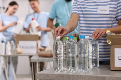 Photo of Group of volunteers packing donation goods indoors, closeup