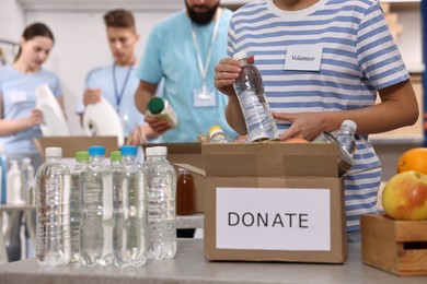 Photo of Group of volunteers packing donation goods indoors, closeup