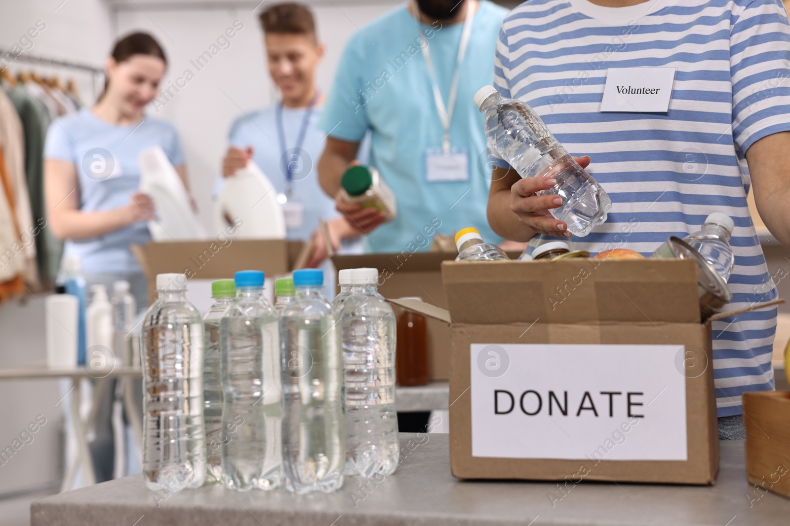 Photo of Group of volunteers packing donation goods indoors, closeup