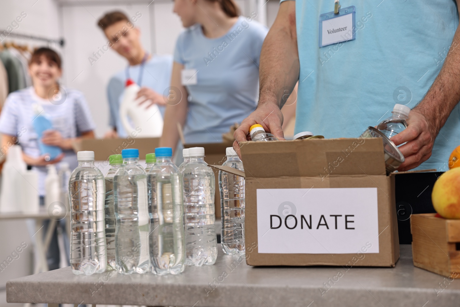 Photo of Group of volunteers packing donation goods indoors, closeup