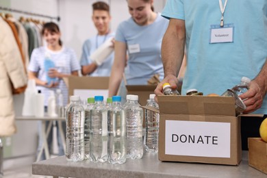 Photo of Group of volunteers packing donation goods indoors, closeup