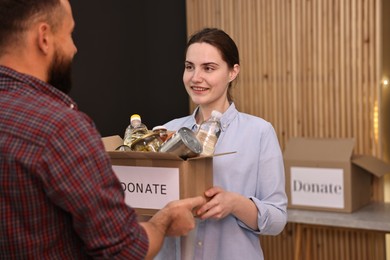 Photo of Volunteers holding donation box with food products indoors