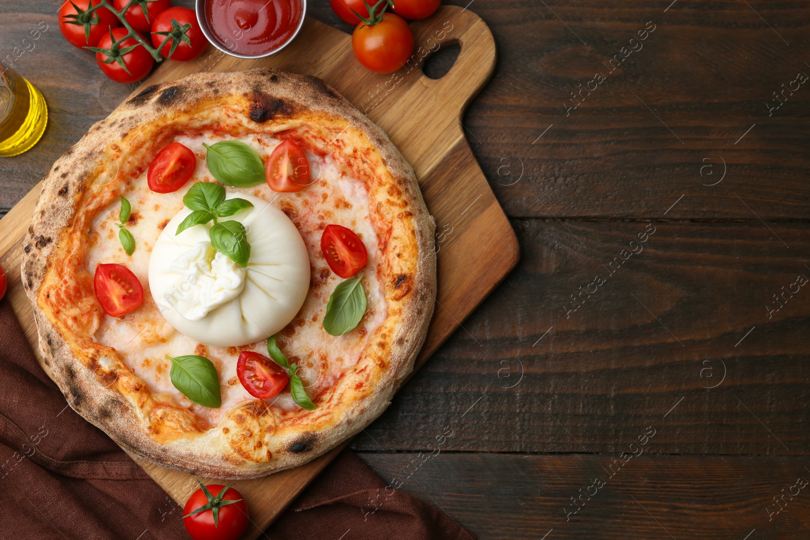 Photo of Delicious pizza with burrata cheese, basil, sauce and tomatoes on wooden table, top view. Space for text