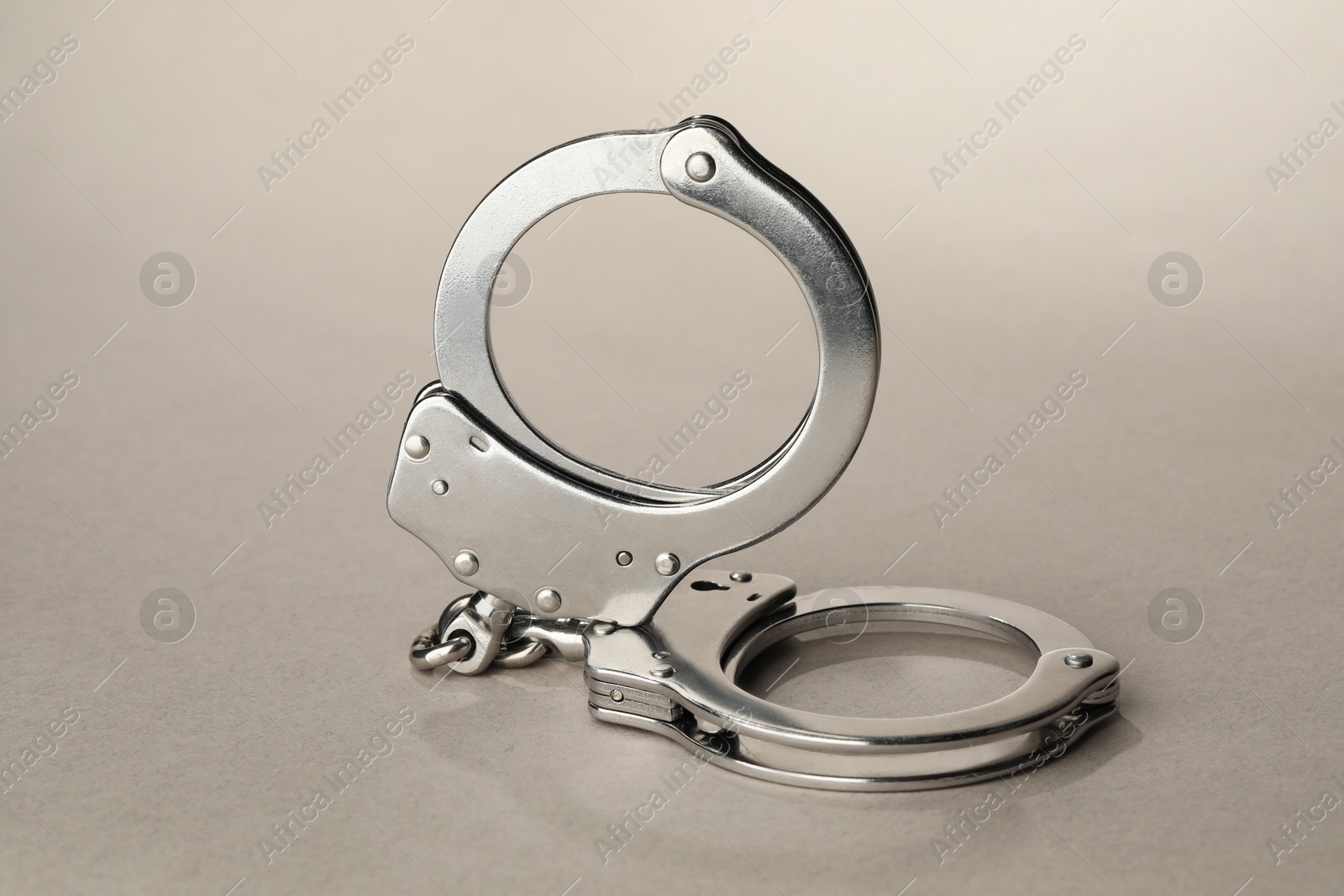 Photo of Metal chain handcuffs on light grey background, closeup