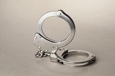 Photo of Metal chain handcuffs on light grey background, closeup