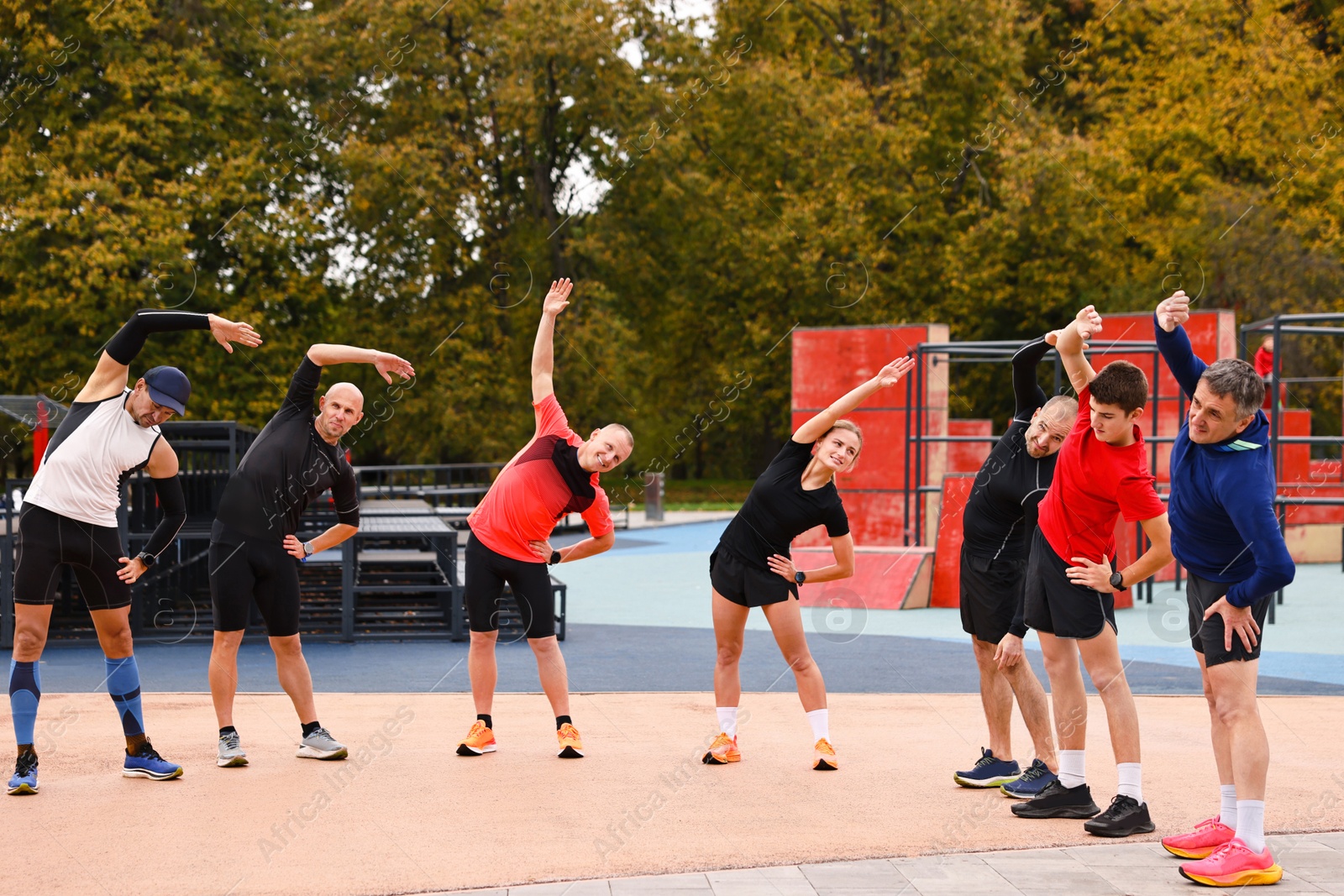 Photo of Group of people exercising and stretching outdoors