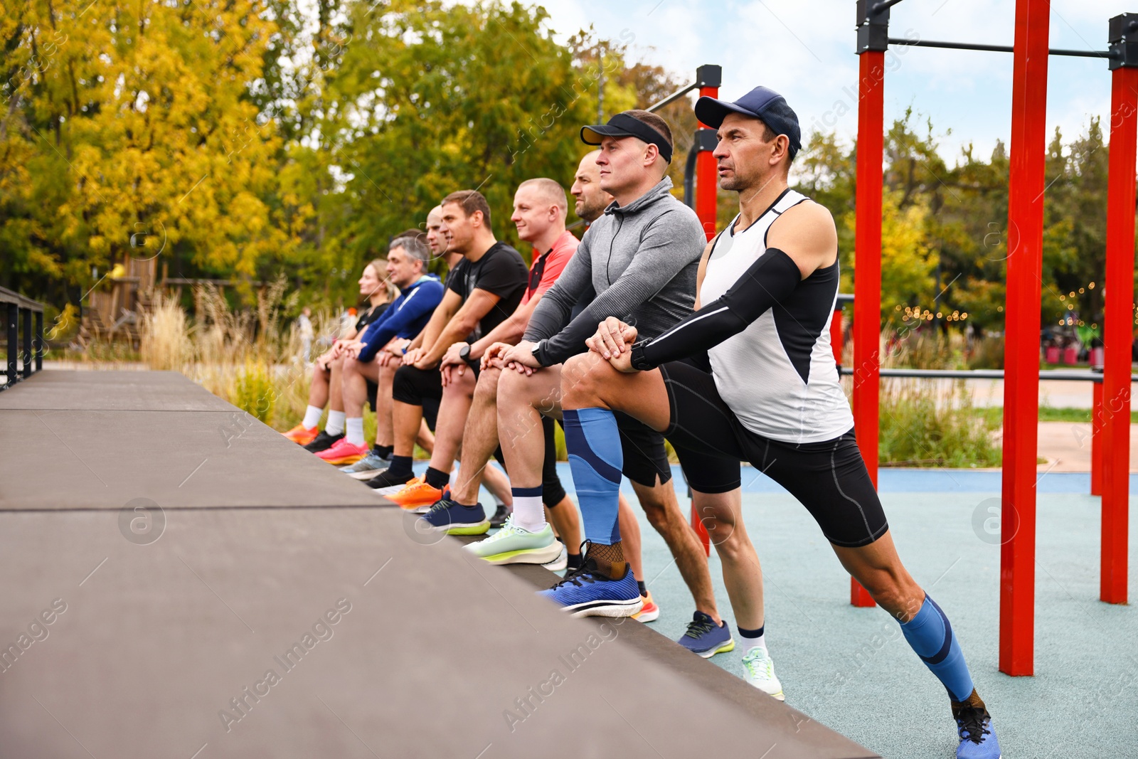 Photo of Group of people stretching in park. Healthy lifestyle