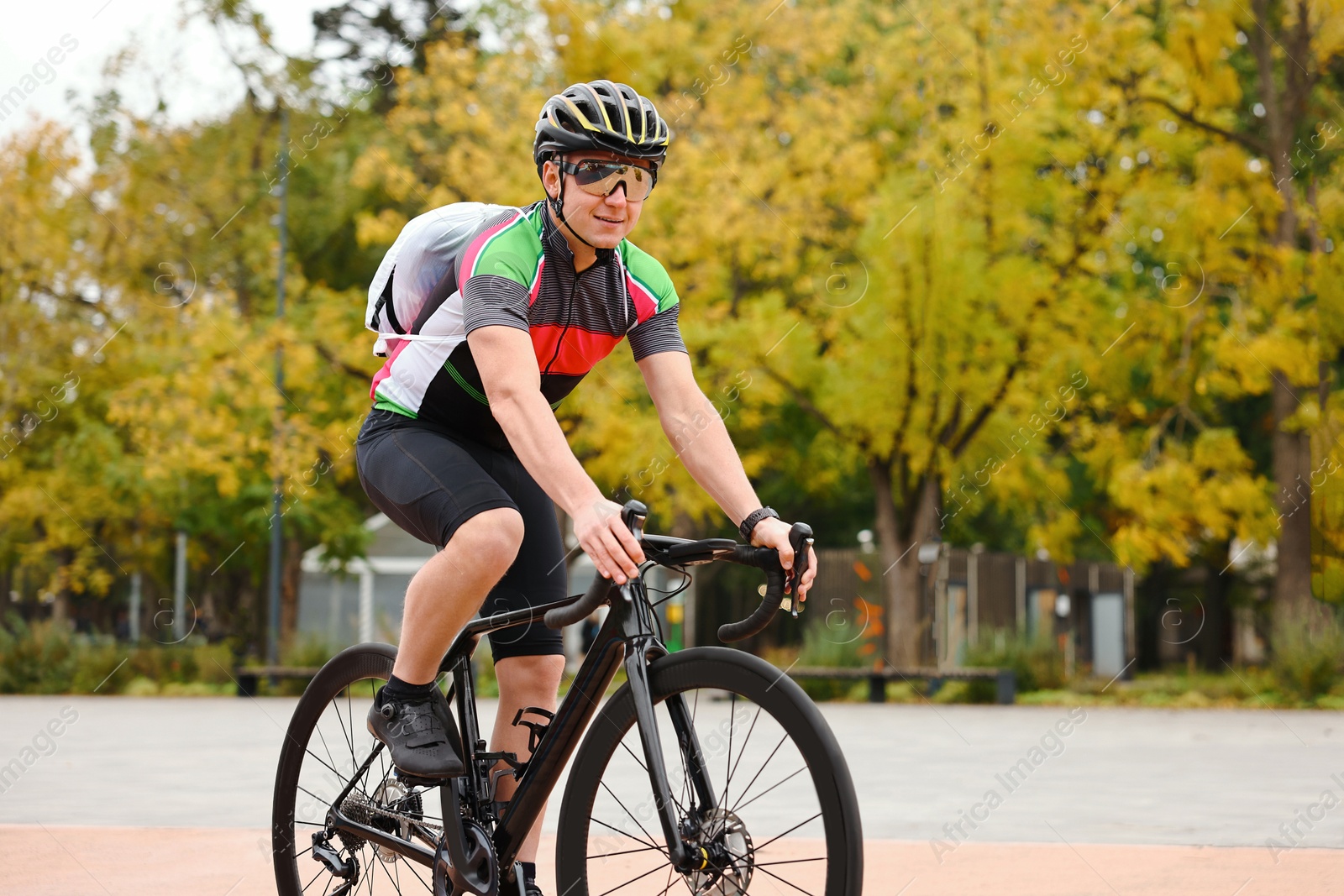 Photo of Athletic man with helmet riding bicycle outdoors