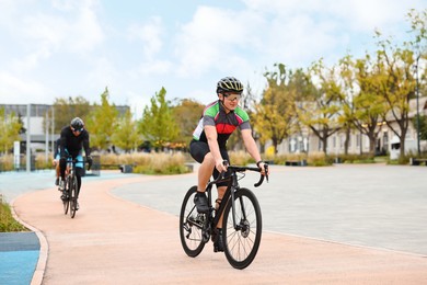 Photo of Group of athletic people riding bicycles outdoors