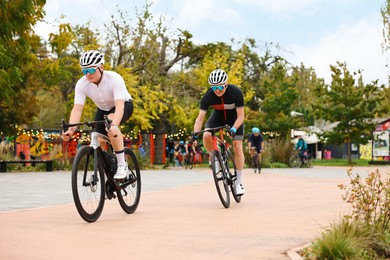 Photo of Group of athletic people riding bicycles outdoors