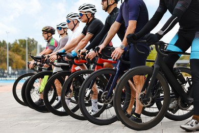 Photo of Group of athletic people with bicycles outdoors