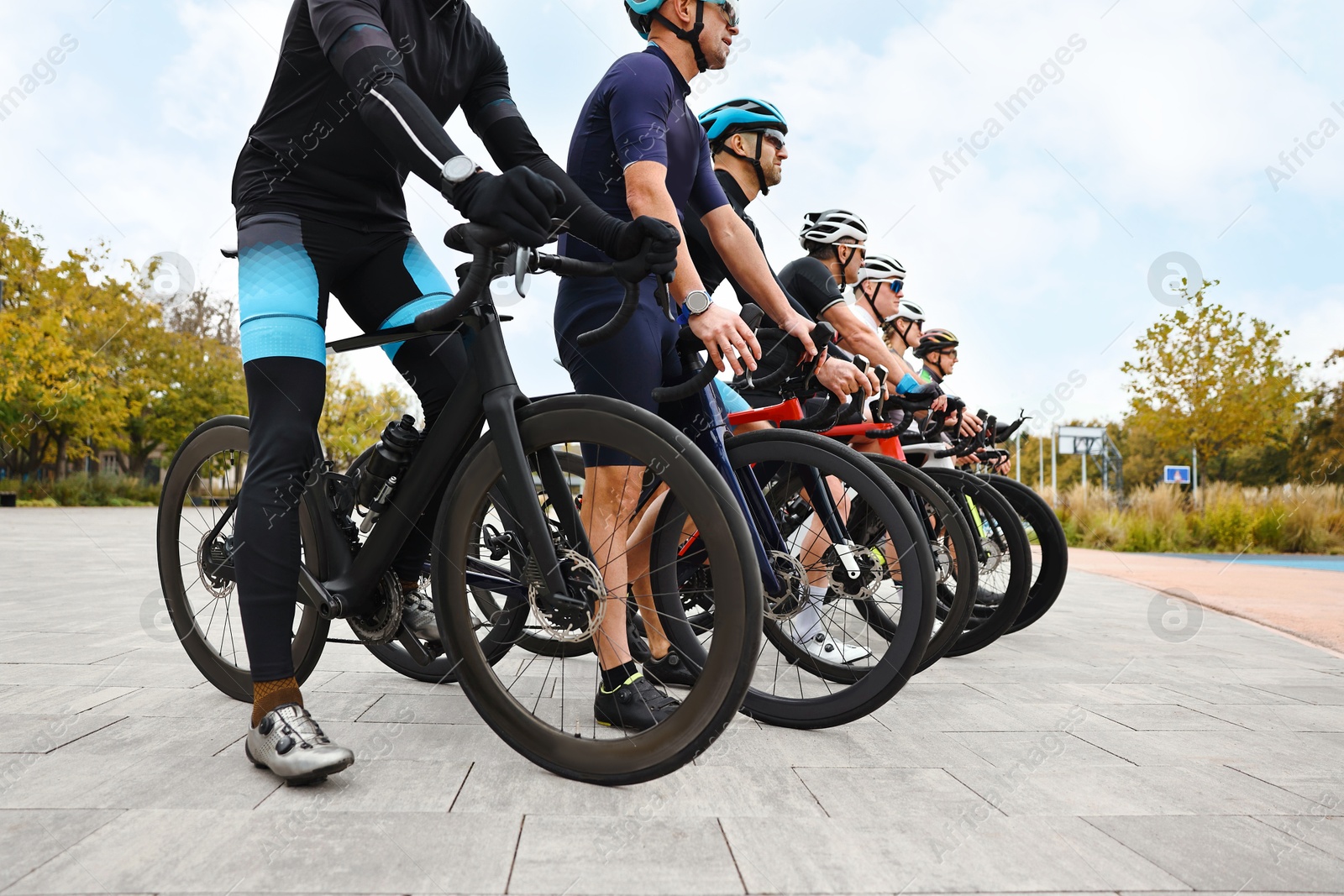 Photo of Group of athletic people with bicycles outdoors