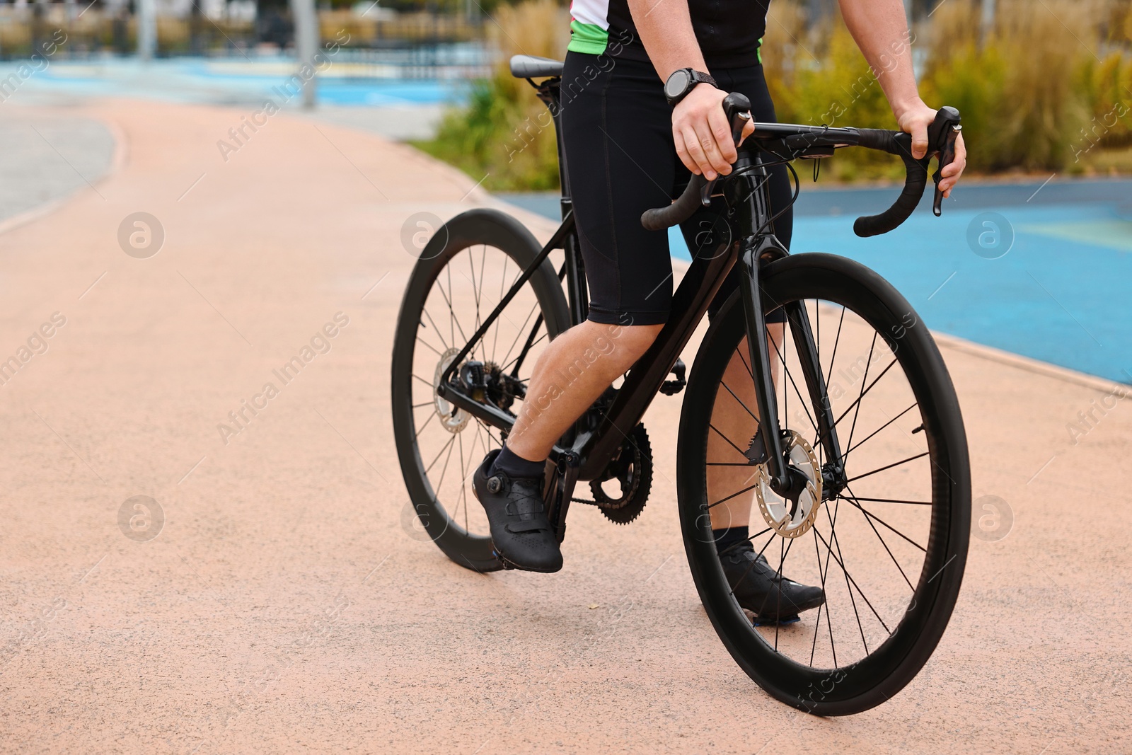 Photo of Athletic man with bicycle outdoors, closeup. Space for text