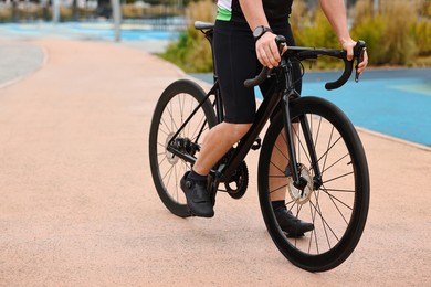 Photo of Athletic man with bicycle outdoors, closeup. Space for text